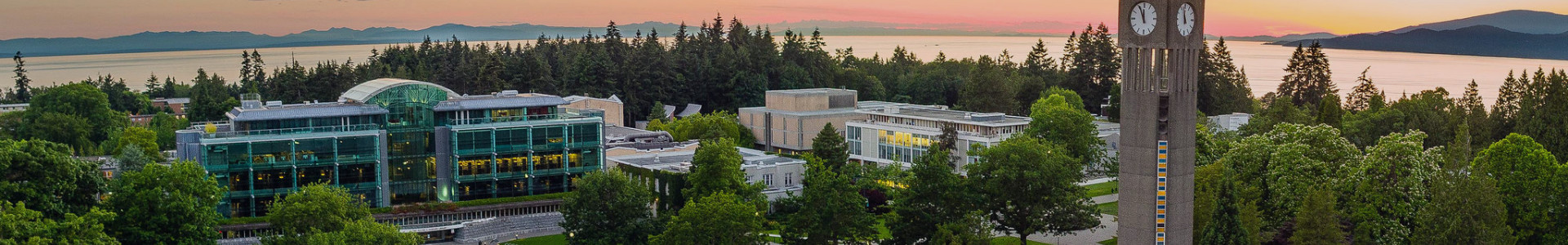 Aerial view of UBC Vancouver campus with forest in the foreground and mountains in the background